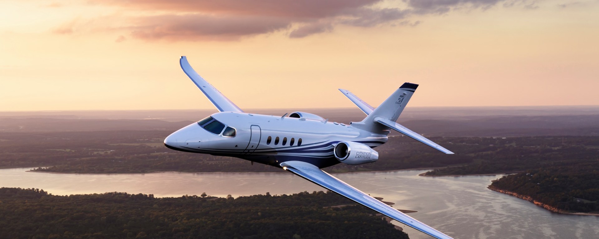 Cessna Citation Latitude flying over a river